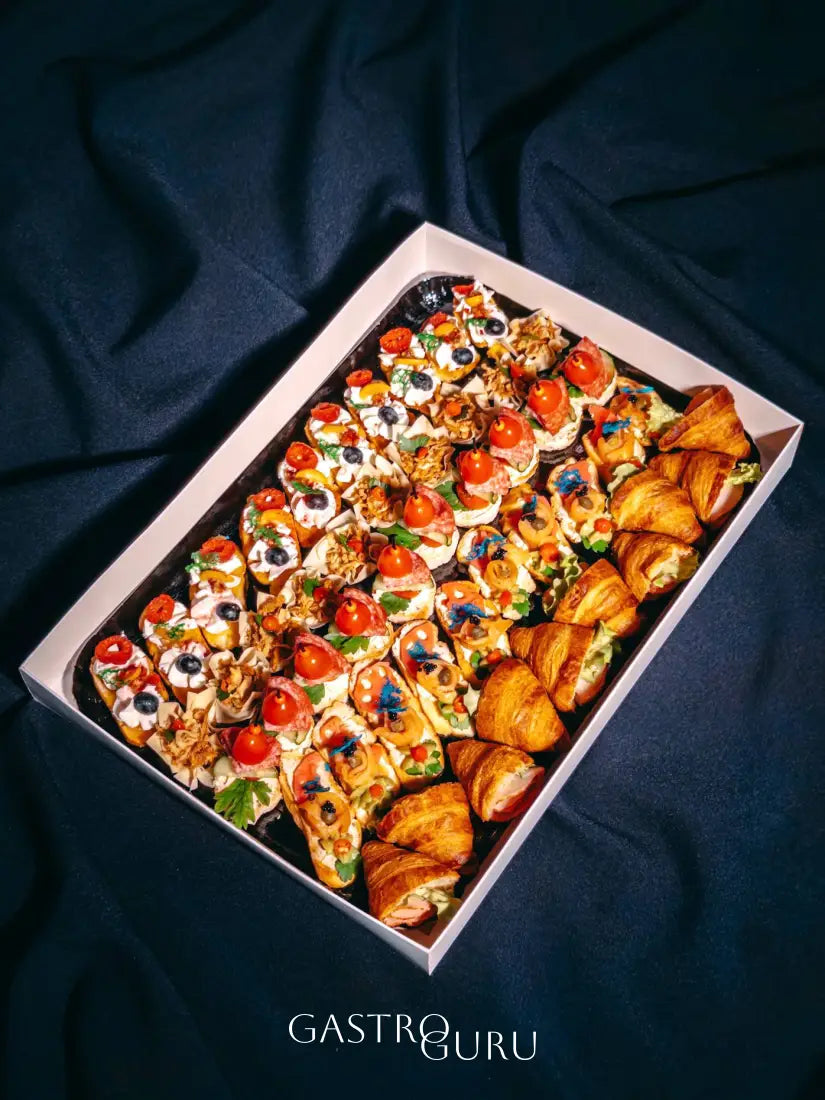 Vieno kąsnio užkandžių rinkinys, prabangūs sumuštiniai ir kruasanai baltoje dėžutėje