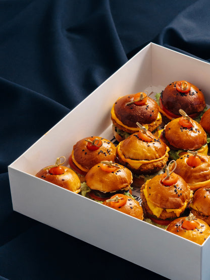 Mini burgerių rinkinys baltoje dėžutėje skirtoje pristatymui